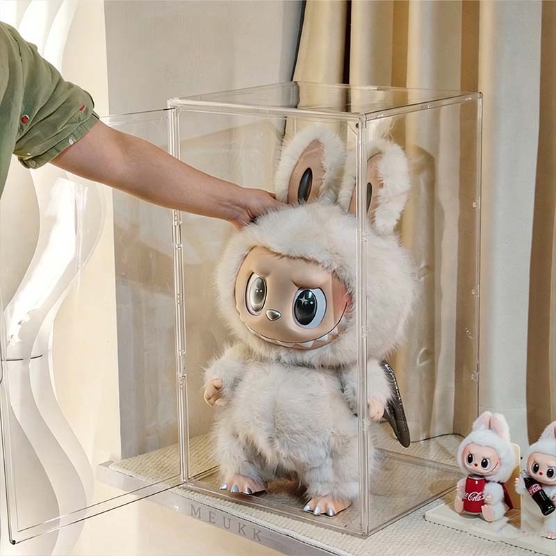 Opening the magnetic door of a tall clear acrylic display case to clean the interior