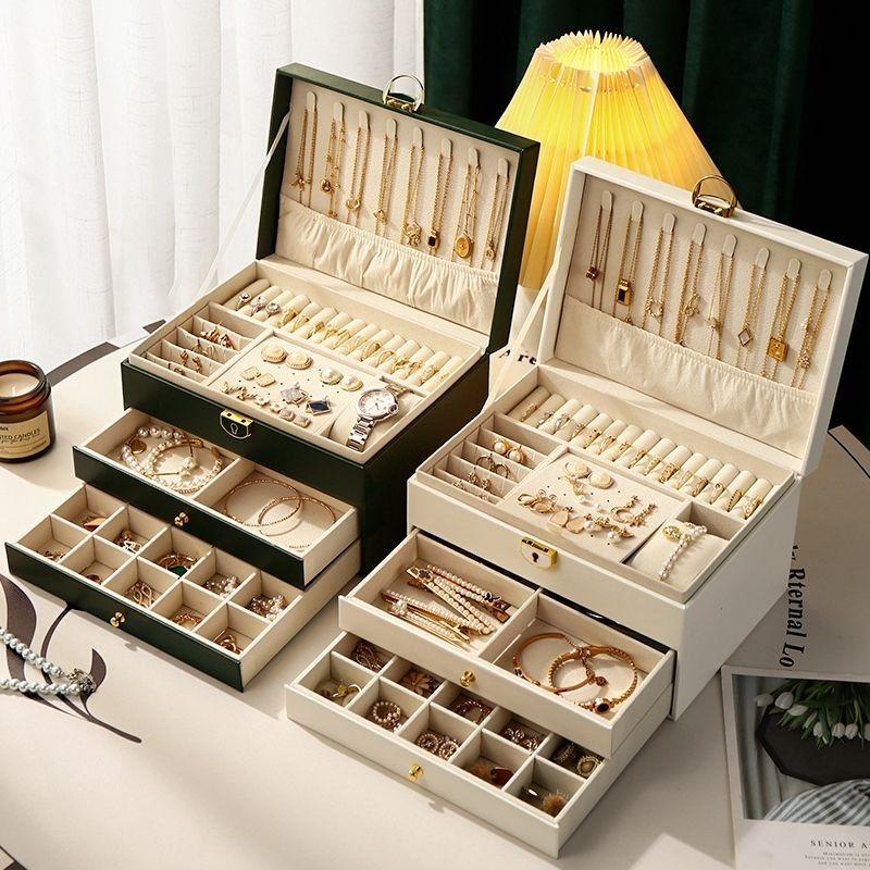 Multi-layer jewelry box with lock open showing necklace hooks, ring rolls, earring panel and pull-out drawers