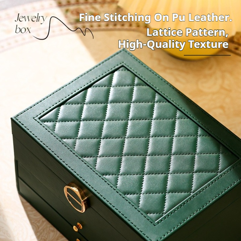 Green jewelry box with lock shown closed on a dresser next to candle and books